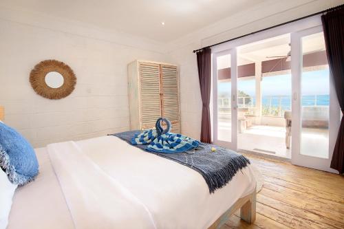 a bedroom with a bed with a view of the ocean at The Point Beach-Front Balangan in Jimbaran
