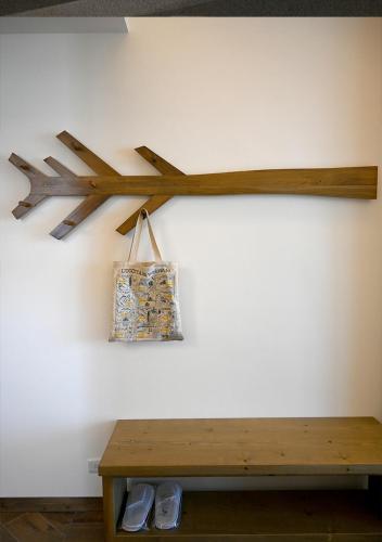 a wooden arrow on a wall with a bench at 澎旅品花灣民宿 in Magong
