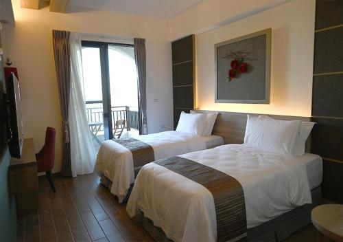 Habitación de hotel con 2 camas y ventana en 澎旅品花灣民宿, en Magong