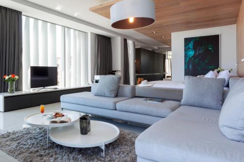 a living room filled with furniture and a tv at POD Camps Bay in Cape Town