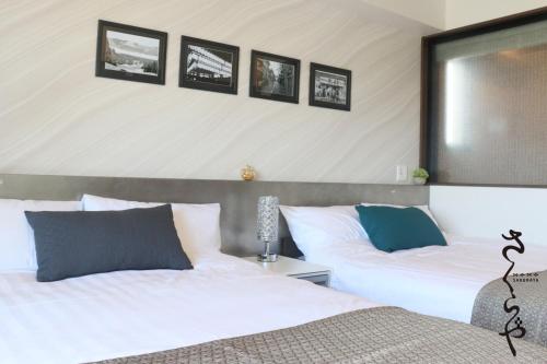 sypialnia z 2 łóżkami i lustrem na ścianie w obiekcie さくらや w mieście Okinawa
