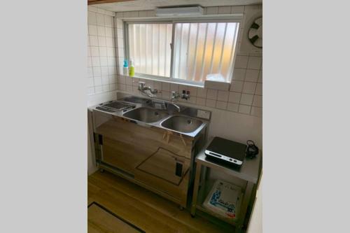 a kitchen with a sink and a mirror at Kyoto Osaka SUMIREYA in Takatuki