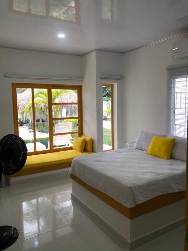 a bedroom with a large bed and a window at Bahia Tropical Sandia Kiwi Piña in Coveñas