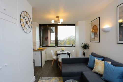a living room with a blue couch and a table at Aisiki Living at Upton Road, Multiple 1, 2, or 3-Bedroom Apartments, King or Twin Beds with Free Wi-Fi & Parking Space in Watford