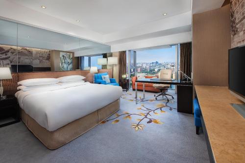 a bedroom with a large bed and a desk with a television at Crowne Plaza Beijing Sun Palace, an IHG Hotel in Beijing