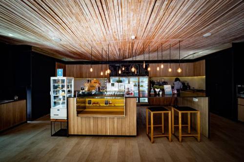 a kitchen with a bar with stools and a counter top at Good Living By Veranda Residence Pattaya in Na Jomtien