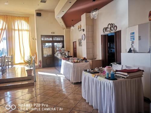 een kamer met twee tafels met witte tafelkleden bij Chrysorama Rooms in Kalabaka