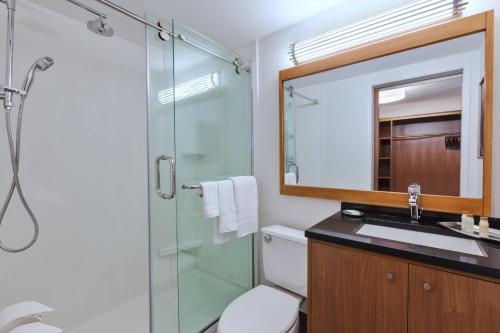 a bathroom with a shower and a sink and a mirror at Hotel Indigo Detroit Downtown by IHG in Detroit