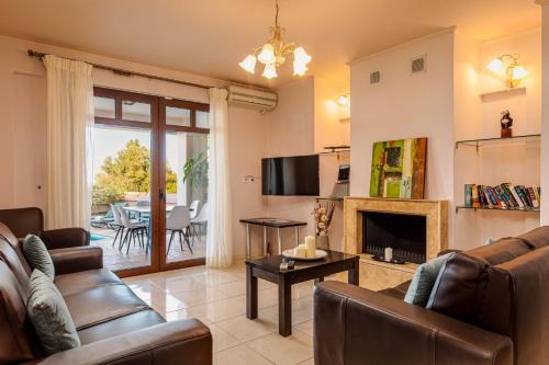 a living room with a couch and a fireplace at Mikra Anogia Villas in Rethymno Town