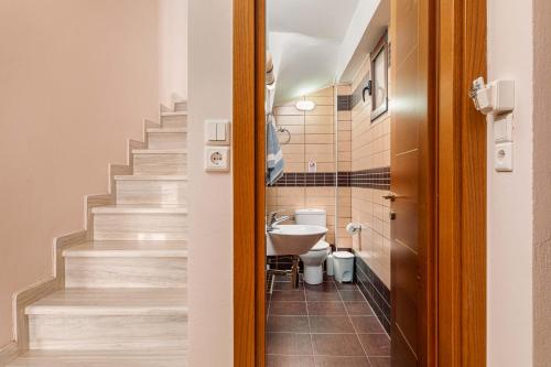 a bathroom with a toilet and a sink and stairs at Mikra Anogia Villas in Rethymno Town