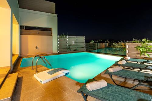 a swimming pool with two lounge chairs on a roof at Mikra Anogia Villas in Rethymno Town