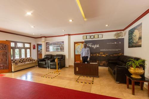 a living room with a man standing in the middle of it at KSTDC Hotel Mayura Bhuvaneshwari Kamalapur in Hampi