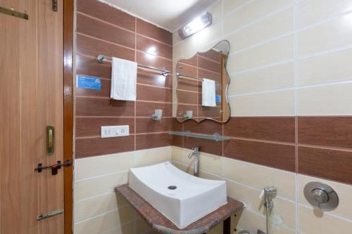 a bathroom with a sink and a mirror at KSTDC Hotel Mayura Bhuvaneshwari Kamalapur in Hampi