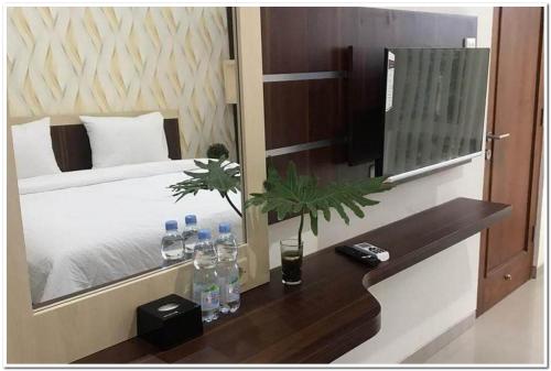 a bedroom with a bed with a mirror and bottles of water at RedDoorz Syariah at Omah Sawah in Balong