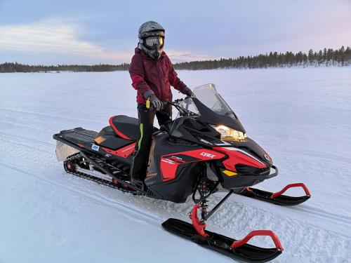 a person riding a snowmobile on a snow covered field at Villa Björklund - Lakeview Apartment in Arjeplog