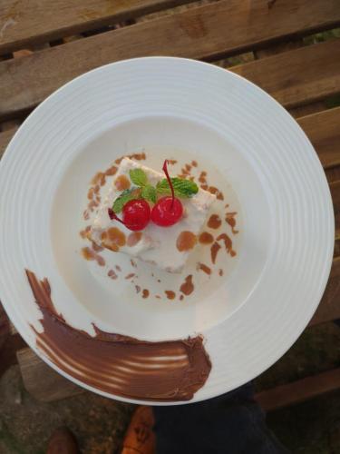 a white plate with a dessert with a cherry on it at Buena Vida Beach Resort in Morjim