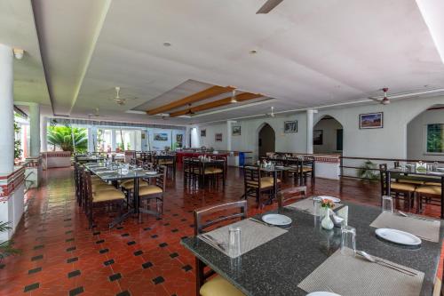 a restaurant with tables and chairs in a room at KSTDC Hotel Mayura Bhuvaneshwari Kamalapur in Hampi