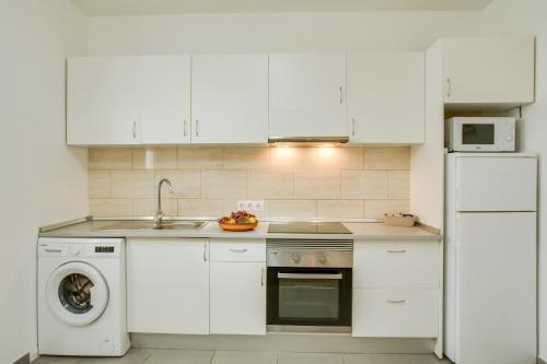 a white kitchen with a sink and a dishwasher at 1a Van Halen in Vecindario