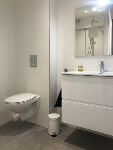 une salle de bain blanche avec des toilettes et un lavabo dans l'établissement Appartement 2 chambres Monte Stella, à Monticello