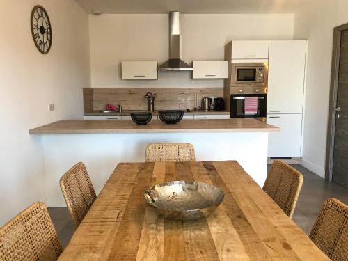 une cuisine avec une table en bois entourée de chaises. dans l'établissement Appartement 2 chambres Monte Stella, à Monticello