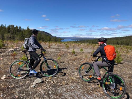 dos personas montando bicicletas en un campo rocoso en Villa Björklund en Arjeplog