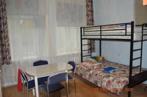 a bedroom with a bunk bed and a table and a desk at гостевой Дом БельвеДеръ in Vyborg
