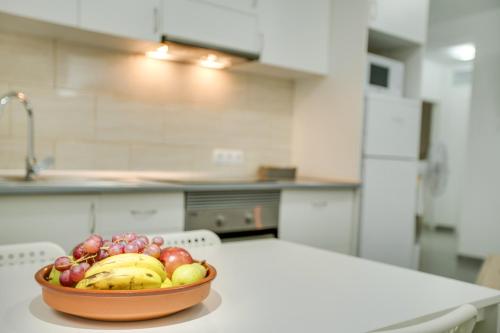 a bowl of fruit sitting on a table in a kitchen at 1b Srv in Vecindario