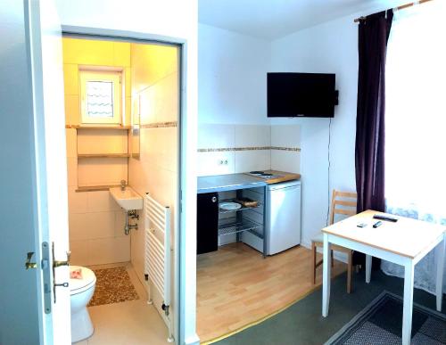 a small bathroom with a toilet and a table at Rustic Overnight Apartment in Osterholz-Scharmbeck