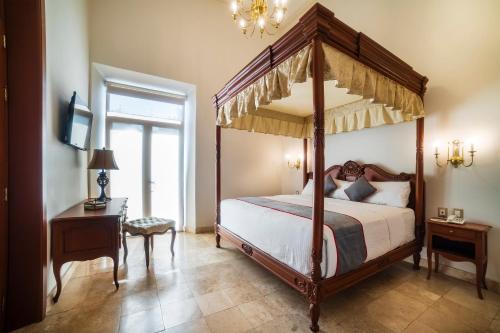 a bedroom with a four poster bed and a window at Hotel Imperial in Veracruz