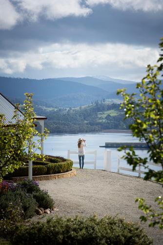 a woman taking a picture of a body of water at Villa Talia Tasmania in Wattle Grove