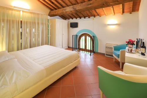 sypialnia z łóżkiem, biurkiem i kanapą w obiekcie Agriturismo Streda Wine & Country Holiday w mieście Vinci
