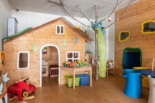 a play room with a toy house and a tree at Josef Mountain Resort in Avelengo