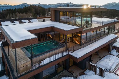 a house with a swimming pool in the snow at Josef Mountain Resort in Avelengo
