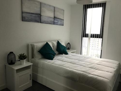 1 dormitorio con 1 cama blanca grande y ventana en Lapwing - Sleeps up to 6, Fabulous panoramic city views, 12th Floor 2 bed city centre apartment, Perfect for work or leisure! en Sheffield