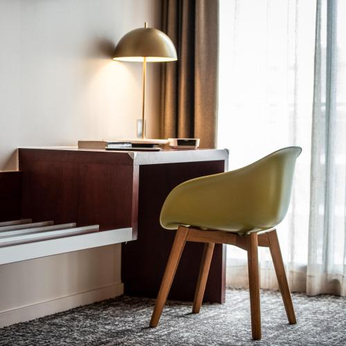 a chair in front of a desk with a lamp at Best Western Aquakub in Aix-les-Bains