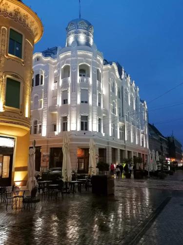 a white building with tables and chairs in front of it at Spiegel Center in Oradea
