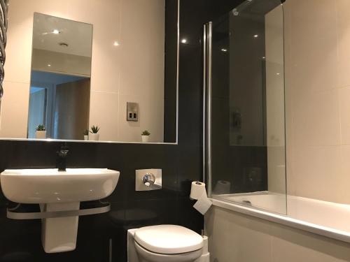 a bathroom with a sink and a toilet and a shower at Lapwing - Sleeps up to 6, Fabulous panoramic city views, 12th Floor 2 bed city centre apartment, Perfect for work or leisure! in Sheffield