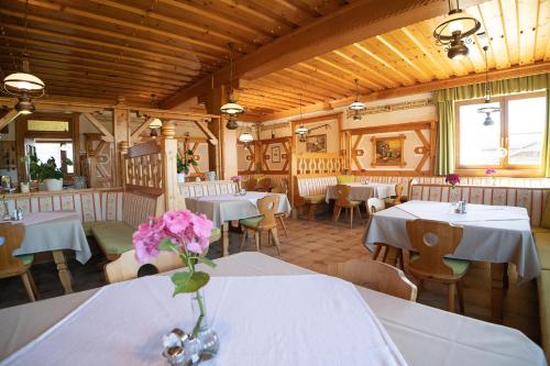 a restaurant with tables and chairs and a vase of flowers at Hotel-Gasthof Deixelberger in Wolfsberg