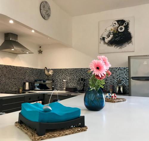 a kitchen with a vase with a flower on a counter at Le cocon de Louise-Vieux Port in Marseille