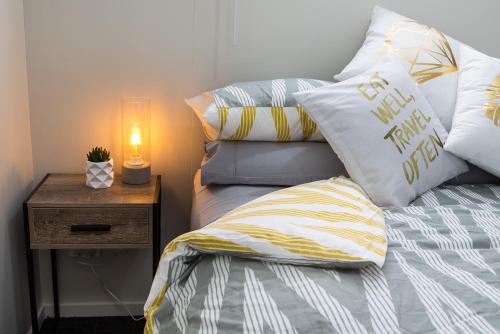 un letto con cuscini e una lampada su un comodino di HOH - Chalet Frodo a Matamata
