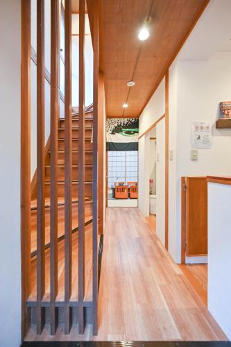a hallway with wooden stairs in a house at 鴨川 栄の屋 Kamo River Machiya Halo House in Kyoto