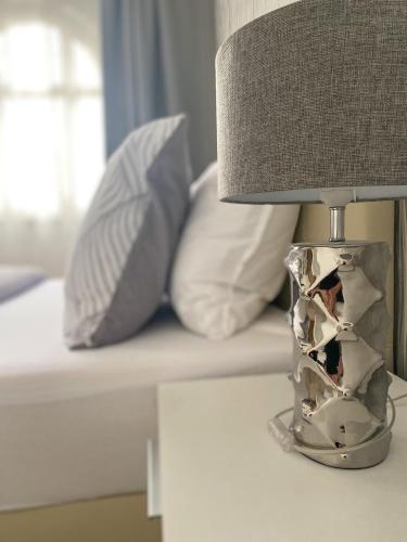 a lamp sitting on a table next to a bed at GrandLux Villa & Spa in Teplice