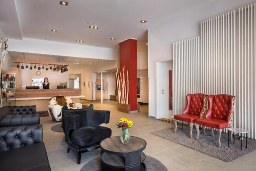 a living room with red and black chairs and a couch at Sure Hotel by Best Western Muenchen Hauptbahnhof in Munich