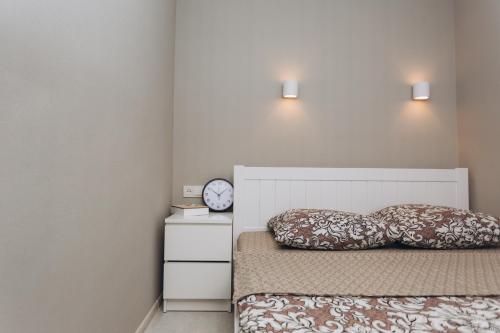 a bedroom with a bed with two pillows and a clock at Apart-hotel I. Sirko New Building 7 floor in Sumy