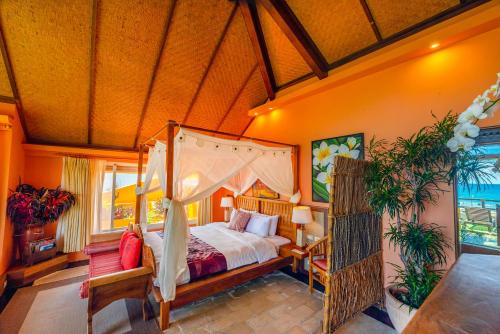 a bedroom with a canopy bed in a room at Red Garden Resort in Eluan