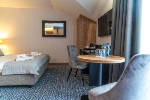 a hotel room with a bed and a table at Hotel Meta Resort & Vine SPA in Szczyrk