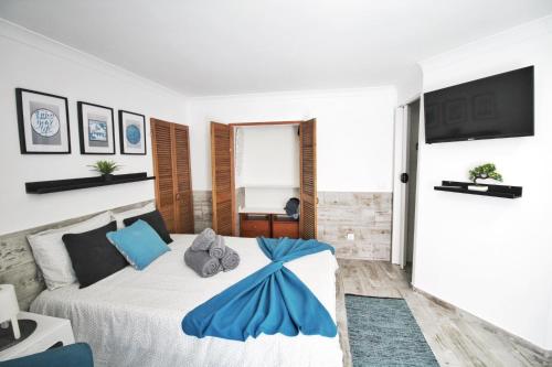 Un dormitorio con una cama con una manta azul. en Estúdio Doce Lar, en Peniche