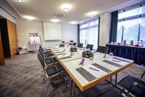 a conference room with a long table and chairs at Mercure Hotel Riesa Dresden Elbland in Riesa
