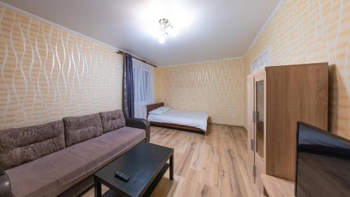 sala de estar con sofá y cama en Апартаменты на Бирули от ApartmentCity, en Mogilev