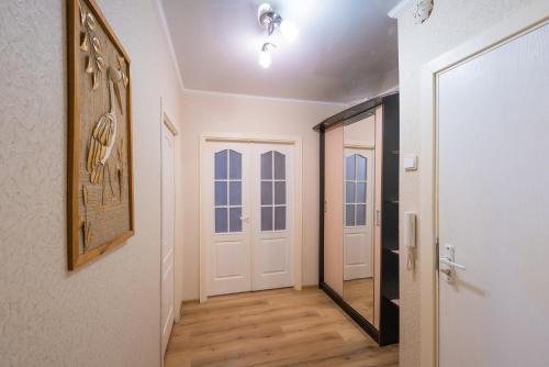 pasillo con puerta blanca y espejo en Апартаменты на Бирули от ApartmentCity, en Mogilev